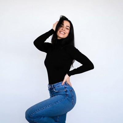 Smiling woman in black turtleneck and jeans