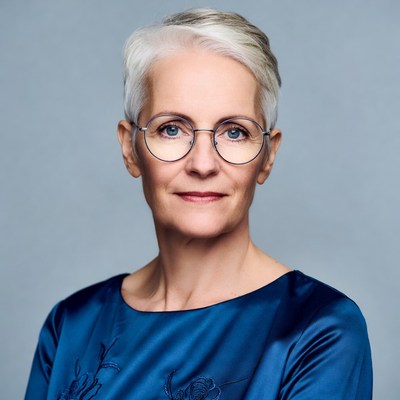 Elderly woman with short white hair and glasses