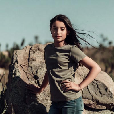 Girl posing by rock outdoors