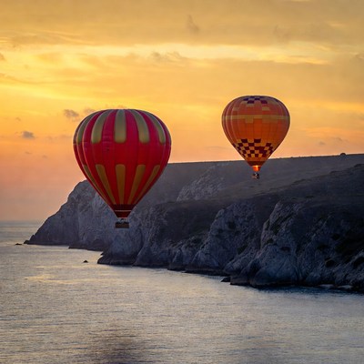Hot air balloons over coastal cliffs