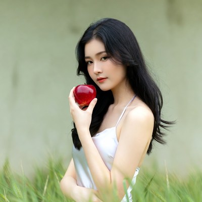 Asian woman holding red apple