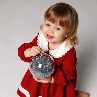 Toddler girl holding Christmas ornament