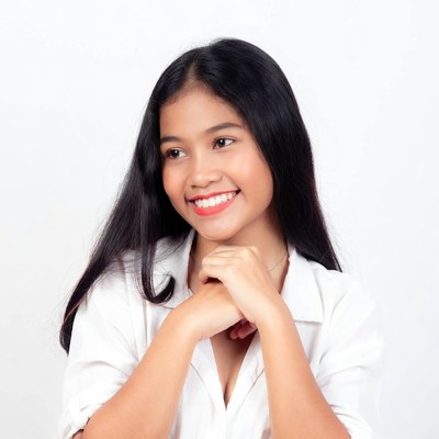 Asian woman smiling with hands clasped
