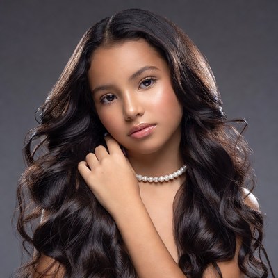 Young girl with long wavy hair and pearl necklace