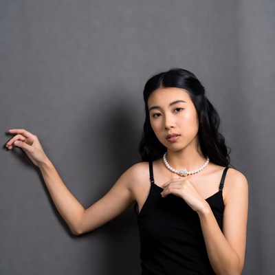 Asian woman in black slip dress