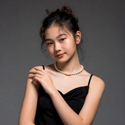 Asian woman in black dress with pearl necklace