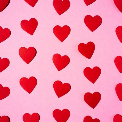 Red paper hearts on pink background