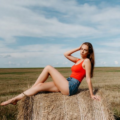 Woman lounging on hay bale