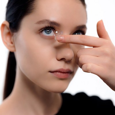 Woman inserting contact lens
