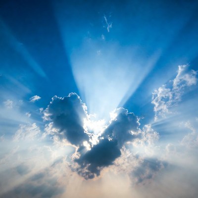 Sunbeams through clouds in blue sky