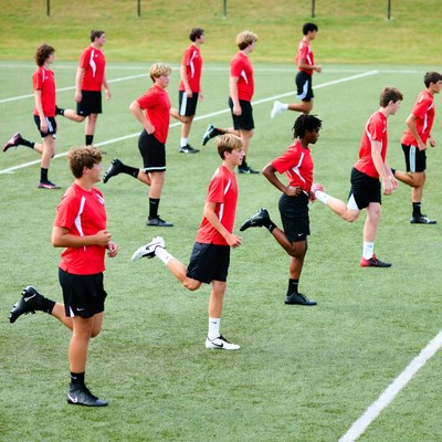 Teen boys stretching on soccer field