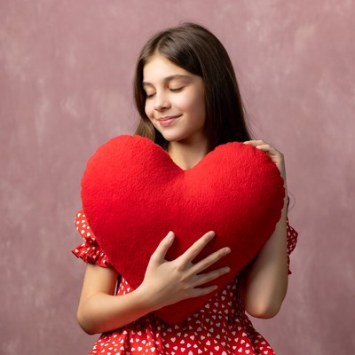 Girl hugging large red heart