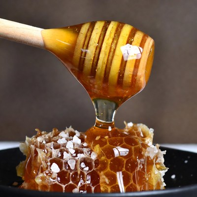 Honey dripping from wooden dipper