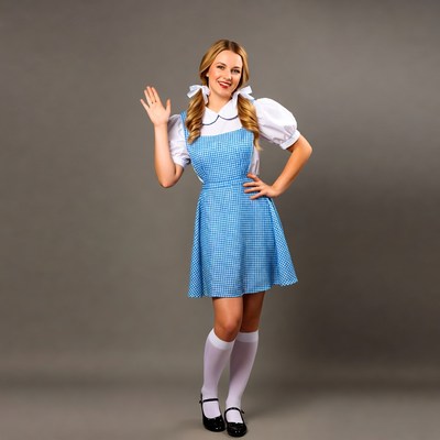 Blonde woman in Dorothy costume waving