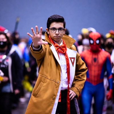 Man cosplaying as Senku holding hand out