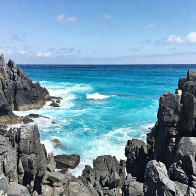Turquoise Ocean Between Black Rock Formations