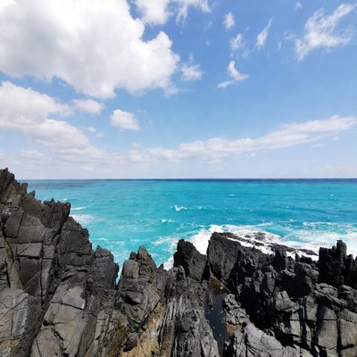 Turquoise Ocean Crashing on Black Rocks