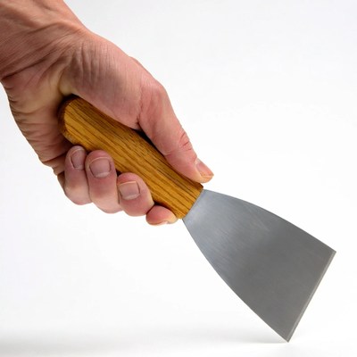 Hand holding putty knife
