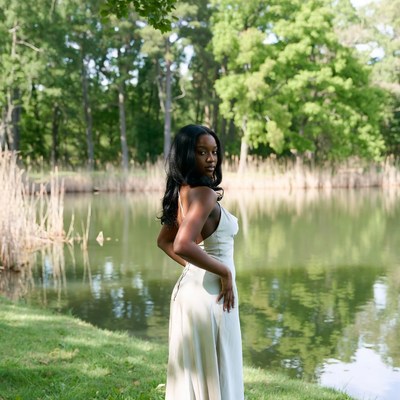 Black woman in white dress by lake