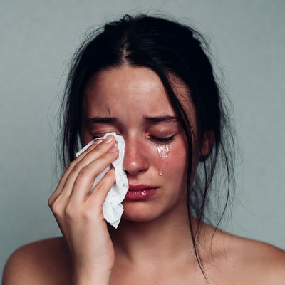 Woman crying holding tissue