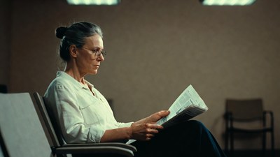 Elderly woman reading newspaper