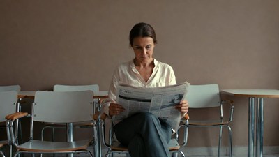 Woman reading newspaper in waiting room