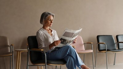 Woman reading newspaper in waiting room