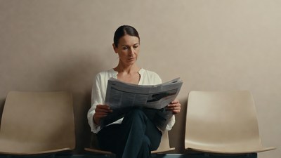 Woman reading newspaper in waiting room