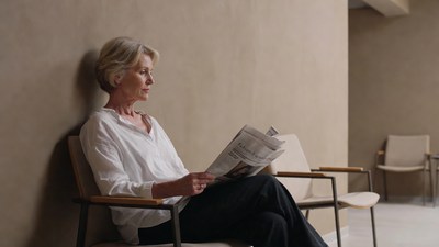 Elderly woman reading newspaper