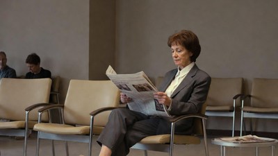 Woman reading newspaper in waiting room