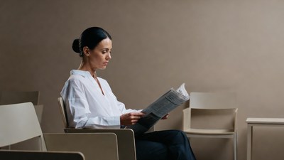 Woman reading newspaper in waiting room