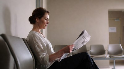 Woman reading newspaper in waiting room