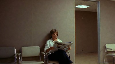 Woman reading newspaper in waiting room