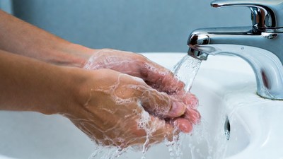 Hands washing with soap under faucet