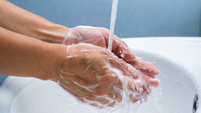 Hands washing with soap under faucet