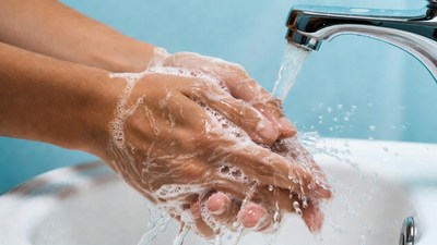 Hands washing with soap under faucet