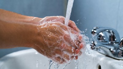 Hands washing with soap under faucet
