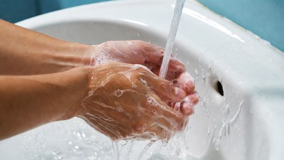 Hands washing with soap under faucet
