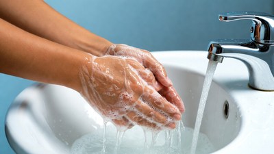 Hands washing with soap under faucet