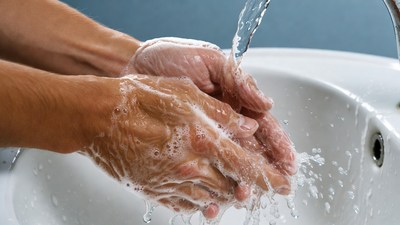 Hands washing with soap under faucet