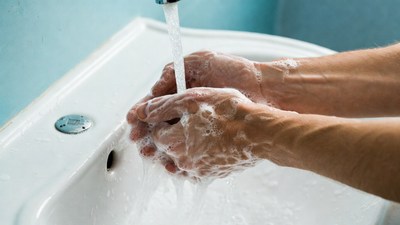 Man washing hands under faucet