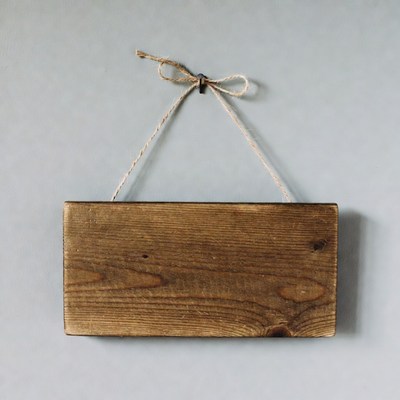 Blank wooden sign hanging by twine