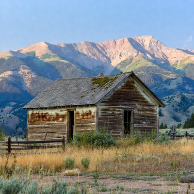 Old wooden cabin with mountains
