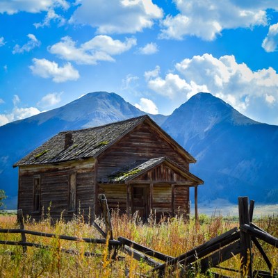 Old wooden cabin with mountains
