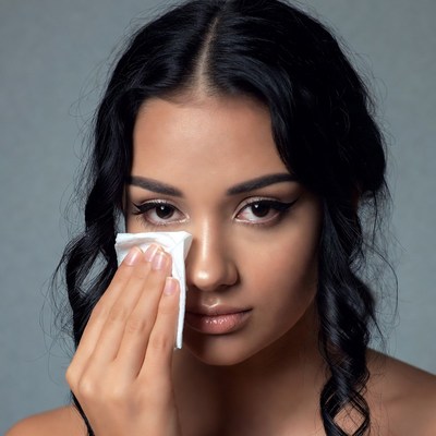 Woman wiping eye with tissue