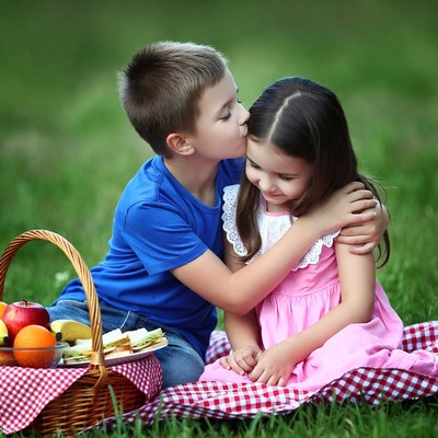 Boy kissing girl on picnic