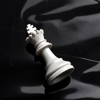 White king chess piece on black fabric