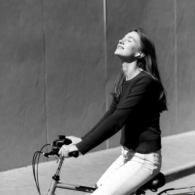 Woman riding bicycle with joyful expression