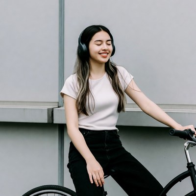 Asian girl smiling with headphones on bicycle