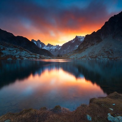 Sunset over alpine lake mountains